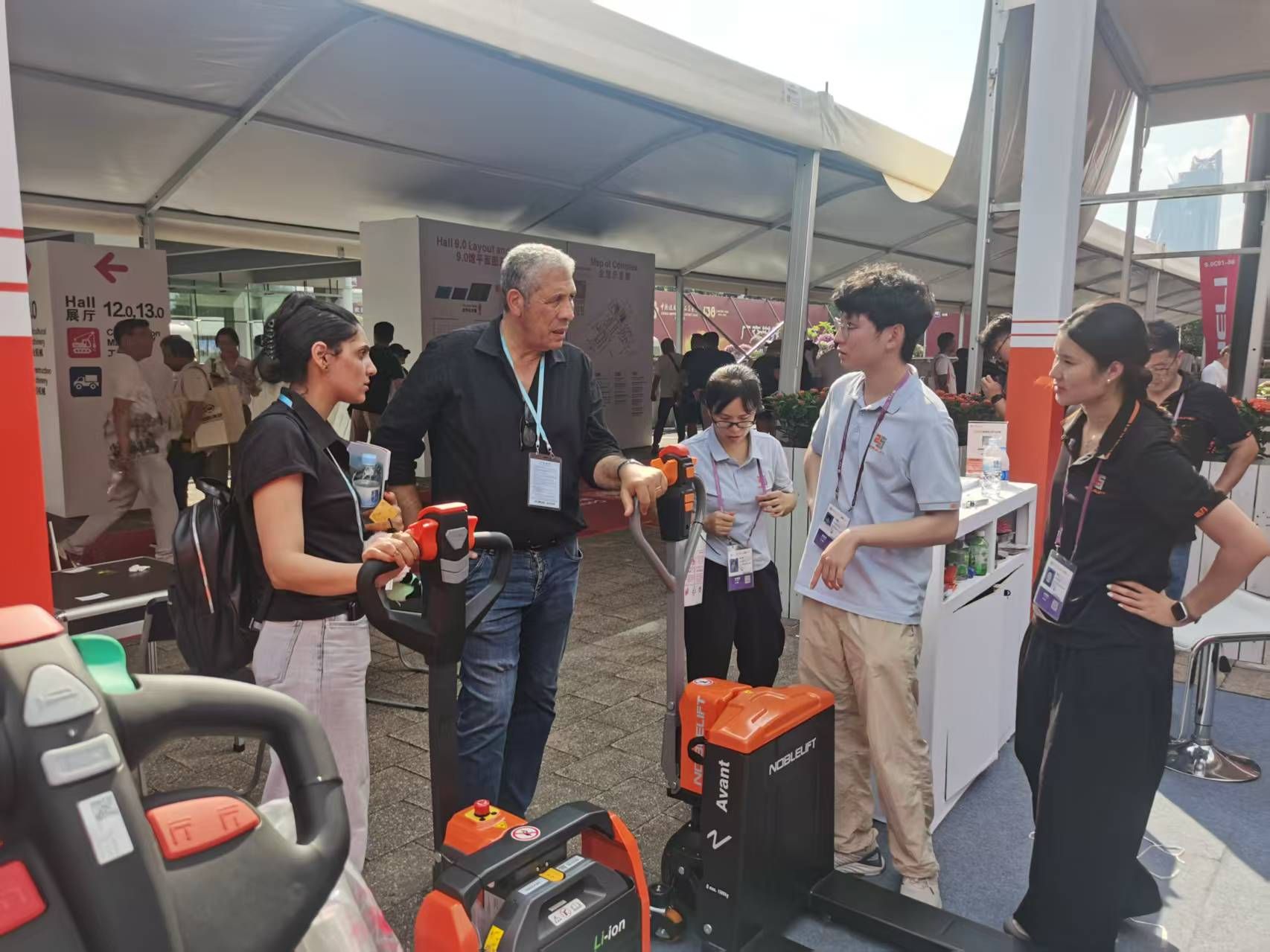 Khách tham quan hội chợ đang được tư vấn về các công nghệ của xe nâng Noblelift